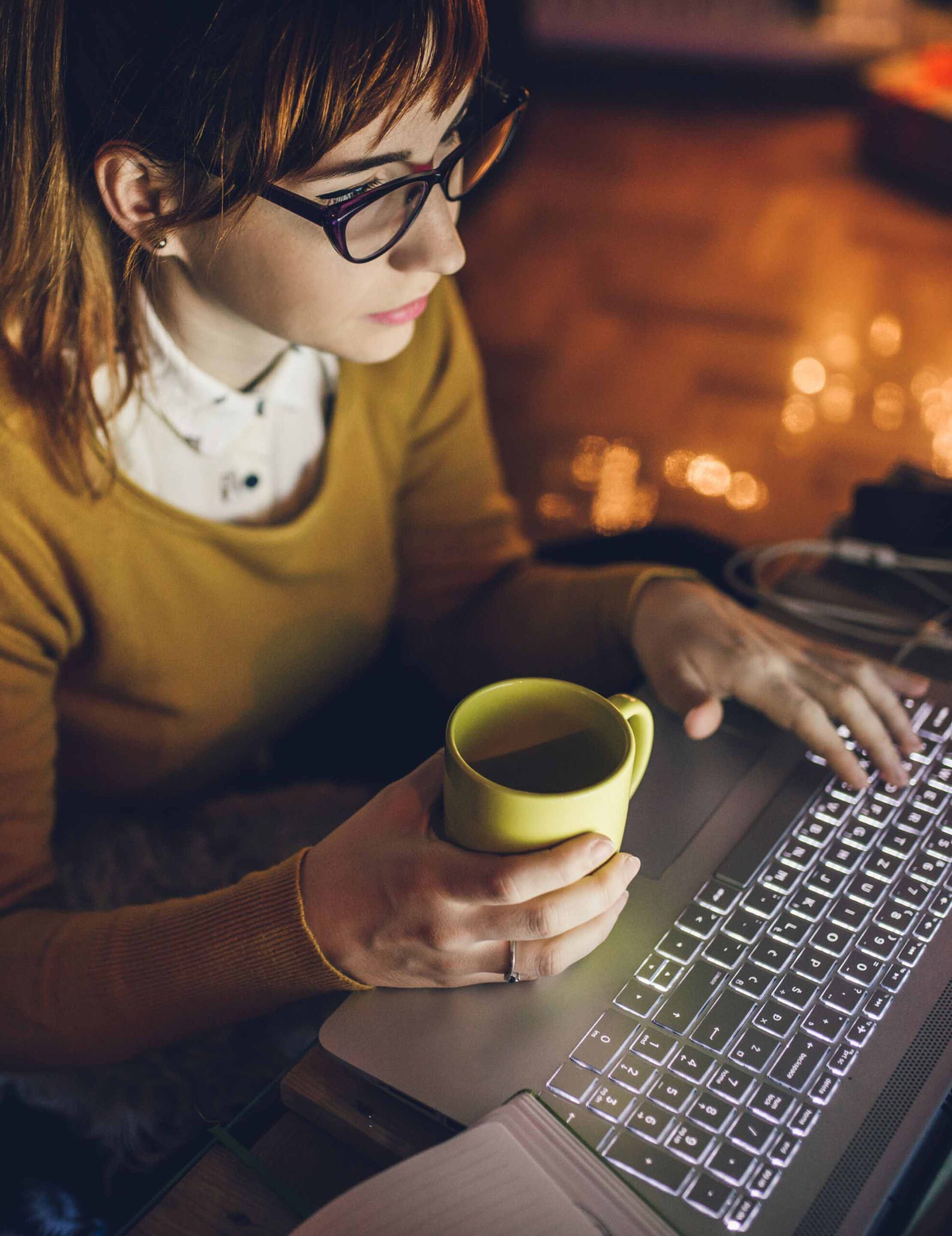 A girl working at night coffee in hand